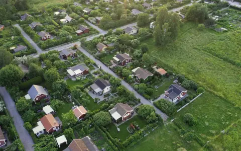 Malownicze ukształtowanie terenu z rzędem czerwonych domków i bujną zielenią.