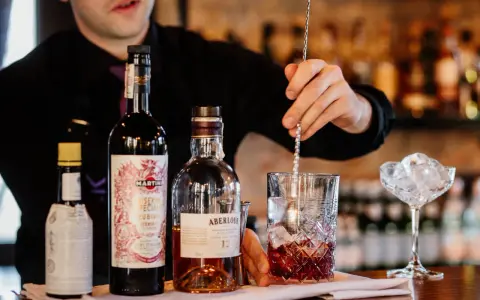 Barman miesza składniki na klasycznego Manhattan drinka. Obok butelki whisky Aberlour i Martini Riserva Speciale Rubino.