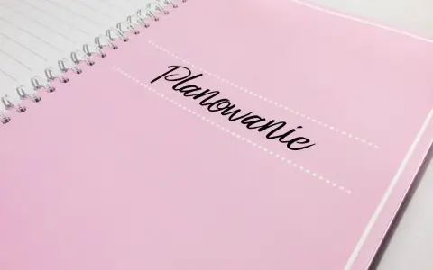 Różowy notatnik z napisem "Planowanie" pomoże Ci ustalić, kogo zaprosić na wesele.