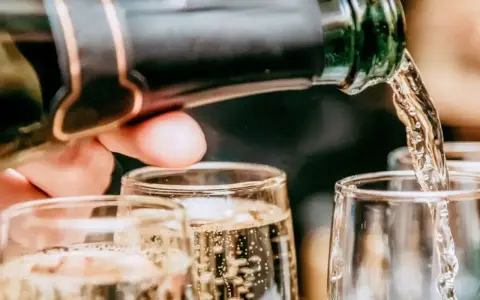 Un verre se remplit de bulles fines, promesse du meilleur champagne rosé. Une célébration pétillante commence.