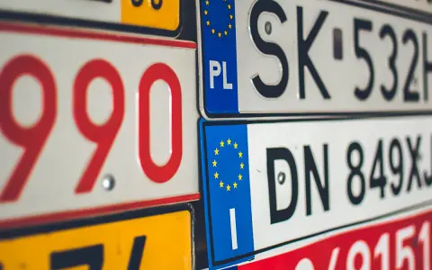 Un'opera d'arte di targhe automobilistiche europee, con numeri rossi e neri su sfondi bianchi e gialli.