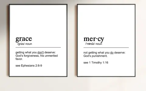 Two framed prints define "grace" as unmerited favor and "mercy" as not getting what you deserve, illustrating the contrast between grace vs mercy.