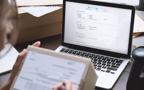 Osoba przygotowuje zwrot kurierem, wypełniając formularz na laptopie. Na ekranie widoczne są dane nadawcy i odbiorcy.
