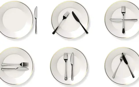 Six assiettes blanches avec des couverts disposés de différentes manières, illustrant la position des couverts signification.