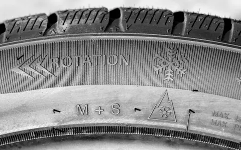 Neumático M+S con indicación de rotación y símbolo de copo de nieve, listo para el invierno.
