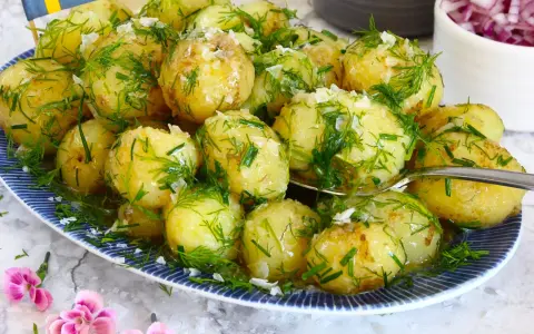 Njut av nykokt färskpotatis med dill och gräslök, en klassiker som visar hur kokar man potatis till perfektion. En svensk flagga vajar stolt.