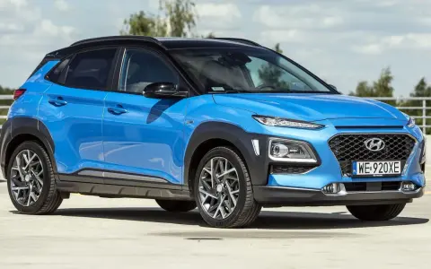 Niebieski Hyundai Kona 2025 z czarnym dachem, zaparkowany na zewnątrz.