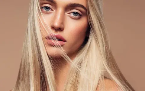 Blondynka z lśniącymi włosami, które wyglądają jak po użyciu płukanki rozjaśniającej.