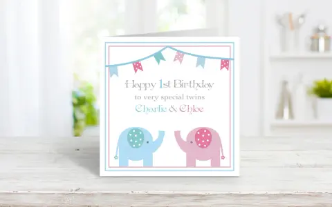 Biglietto di auguri per il doppio buon compleanno gemelli, con elefanti rosa e azzurri e festoni.