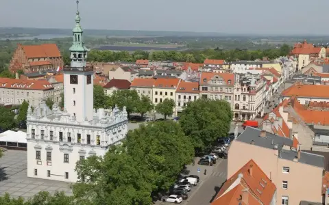 Widok na rynek w Chełmnie z ratuszem i wieżą. W tle kamienice i zieleń, idealne chełmno atrakcje.