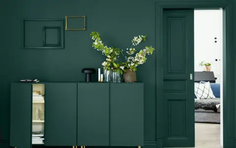 Un buffet vert sapin, des cadres dorés et noirs, des fleurs blanches et roses. Quelle couleur avec le vert sapin ? Le doré ressort magnifiquement.