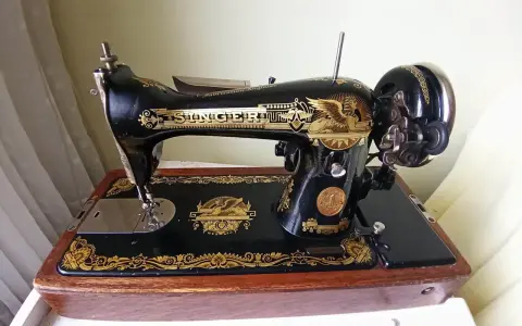 Machine à coudre Singer ancienne, noire et dorée, sur son socle en bois. Le numéro de série est visible pour une estimation.
