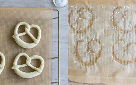 Rohe und gebackene Brezeln auf Backpapier. Links ungeborene, rechts bereits gebackene Brezeln, die zeigen, wie sie aufbacken.