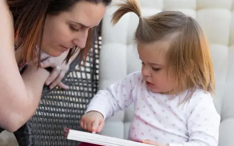 Mama czyta dziecku, a maluch odkrywa świat przez książkę, tworząc własne neologizmy dziecięce.