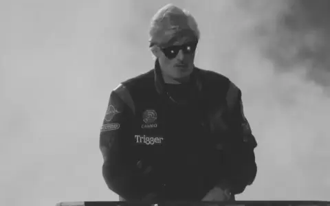 Młody artysta w okularach przeciwsłonecznych, w kurtce z naszywkami, gotowy do występu. Jego styl to czysty ras hip-hop.