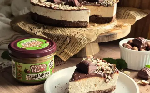 Pyszne ciasto z mascarpone, czekoladą i orzechami laskowymi. Obok słoiczek pasty z orzechów laskowych.