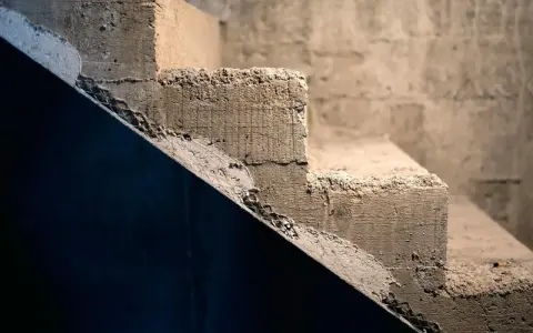 Szare, surowe schody betonowe, wymagające renowacji. Zastanawiasz się, jak odnowić stare schody betonowe wewnętrzne?