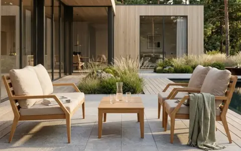 Trädgårdsmöbler i teak med klassisk design, placerade på en altan vid ett modernt hus.