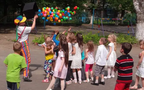 Animator wypuszcza balony, dzieci łapią je z radością. Świetny pomysł na urodziny dla dzieci na świeżym powietrzu!