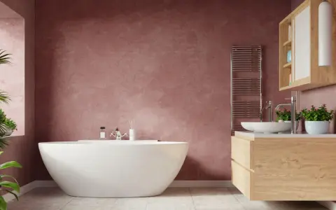 Un elegante bagno con vasca freestanding e mobile lavabo in legno. Le pareti color pesca creano un'atmosfera calda e accogliente, un vero bagno soffitto colorato.