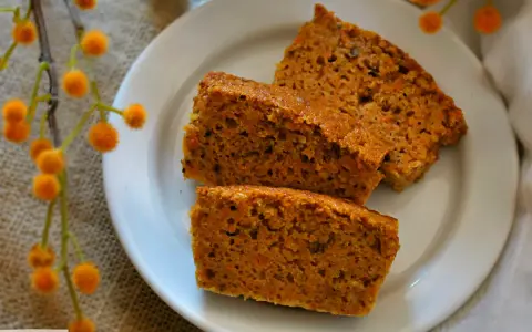 Rebanadas de bizcocho de zanahoria casero, esponjoso y con trocitos de zanahoria visibles, servidas en un plato blanco.