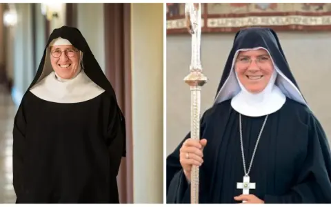 Two smiling nuns in traditional black habits and white wimples. This is what Catholic monks wear, along with a cross necklace and a staff.