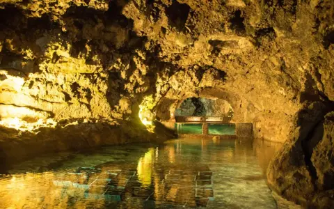 Beleuchtete Höhlen von São Vicente mit einem ruhigen Wasserbecken und Aquarien.