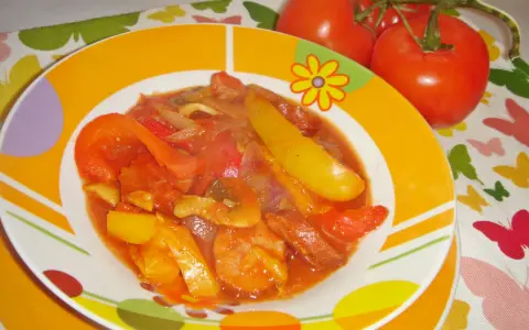 Pyszne leczo z pieczarkami, papryką i pomidorami, podane na kolorowym talerzu.