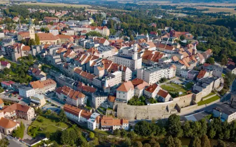 Bystrzyca Kłodzka atrakcje: malownicze miasto z zabytkowym rynkiem, kościołem i murami obronnymi, otoczone zielenią.