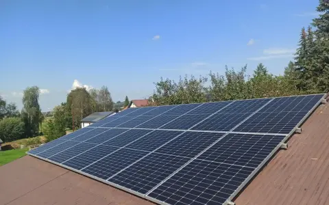 Panele fotowoltaiczne na dachu. Zastanawiasz się nad rozliczeniem rocznym czy miesięcznym? Słońce świeci, produkując czystą energię.