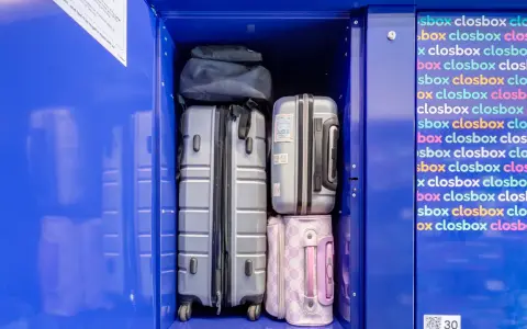 Luggage stored in a blue locker, including suitcases and bags.