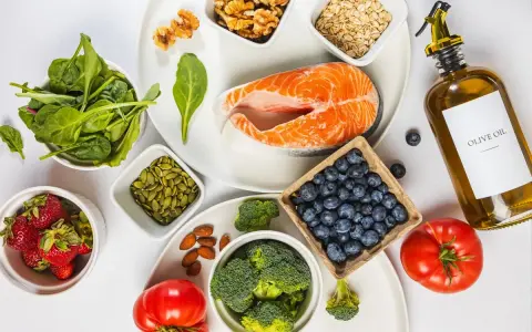 En hälsosam måltid med lax, bär, grönsaker och nötter. Denna inflammation mat är rik på omega-3 och antioxidanter.