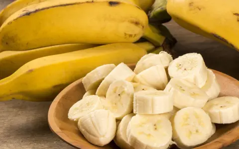 Kawałki banana na drewnianej desce. Banan wartości odżywcze to potas i witaminy.
