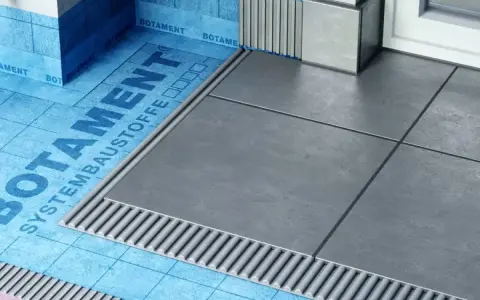 Systemowa hydroizolacja łazienki z niebieską membraną Botament i szarymi płytkami.