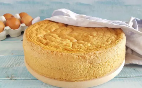 Gâteau moelleux, prêt à être décoré. La base parfaite pour toute recette génoise. Des œufs frais en arrière-plan.