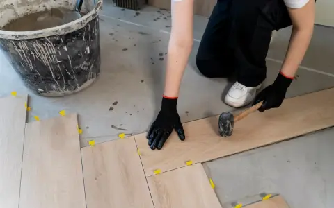 Instalando baldosas de madera, el mejor suelo para garaje particular. Se usa mazo y niveladores.