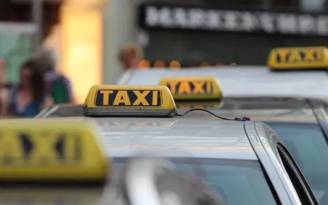 Reihe von Taxis mit gelben Dachschildern. Die aktuellen Taxipreise sind auf den Schildern nicht sichtbar, aber die Fahrzeuge stehen bereit.