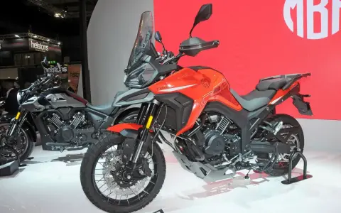 Pomarańczowy motocykl Morbidelli T1002VX na wystawie, gotowy na przygodę. Obok stoi jego szary brat.