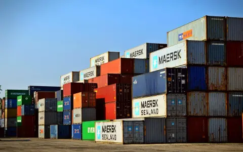 Stos kontenerów w porcie, świadectwo globalnej logistyki Rhenus. Widoczne napisy Maersk, Evergreen, Cronos.