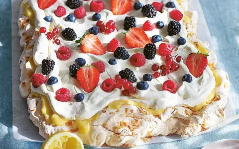 En stor pavlova med grädde och färska bär, perfekt för påskfirandet.