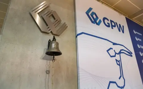 Dzwonek giełdowy GPW, symbolizujący rozpoczęcie obrotu, obok logo giełdy.