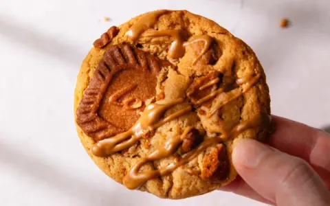 Un biscuit au speculoos, généreusement garni de morceaux et nappé d'une sauce caramel.