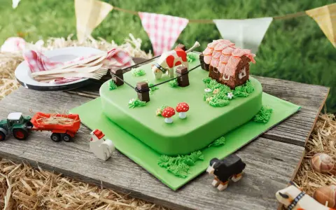 Torta per bambini a tema fattoria con mucca, casetta, trattore e animali.