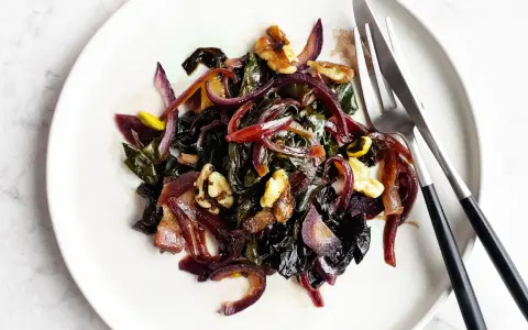 Bietole in padella con cipolla rossa e noci, un contorno saporito e colorato pronto per essere gustato.