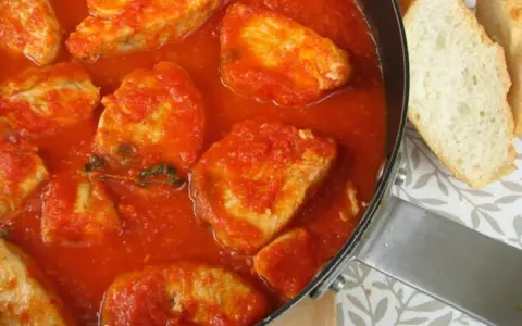 Sabroso pollo en salsa de tomate, como la receta de la abuela. Acompañado de pan crujiente.