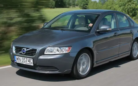 Szary Volvo S40 2.0 diesel w ruchu, z rozmazanym tłem zieleni i drogi.