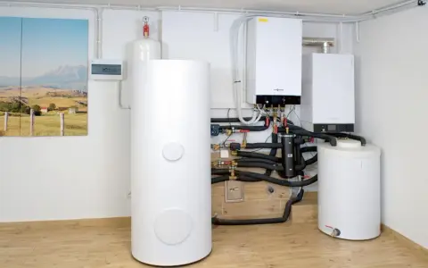 Nowoczesny piec gazowy dwufunkcyjny i zasobnik wody. Instalacja grzewcza z widocznym czujnikiem ciśnienia.