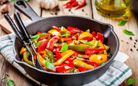 Peperoni in padella, colorati e succosi, pronti per essere gustati. Un contorno semplice e saporito.