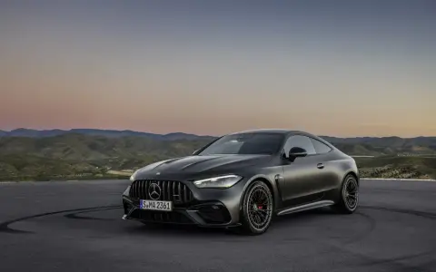 Mroczny Mercedes CLE 53 AMG na tle górskiego krajobrazu o zachodzie słońca.