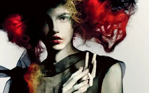 Portret kobiety z ognistymi włosami i czarną siatką, w stylu Paolo Roversi.